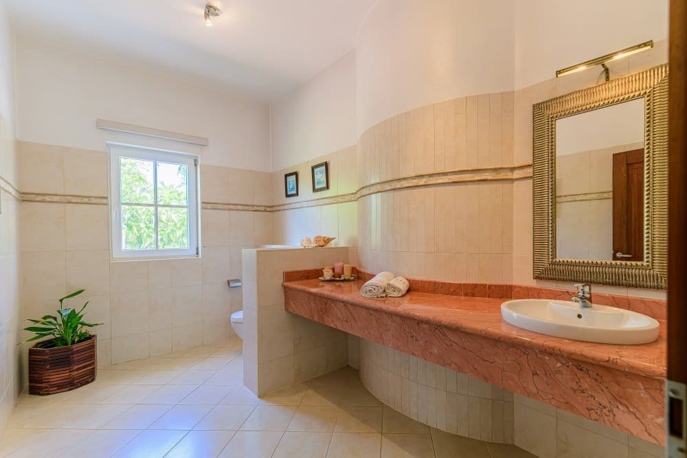 buyDRproperty Luxurious bathroom with marble vanity, white sink, and ornate mirror Sosua Real Estate