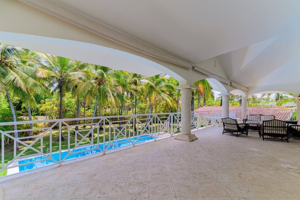 buyDRproperty Spacious balcony overlooking a tropical pool and palm trees Sosua Real Estate