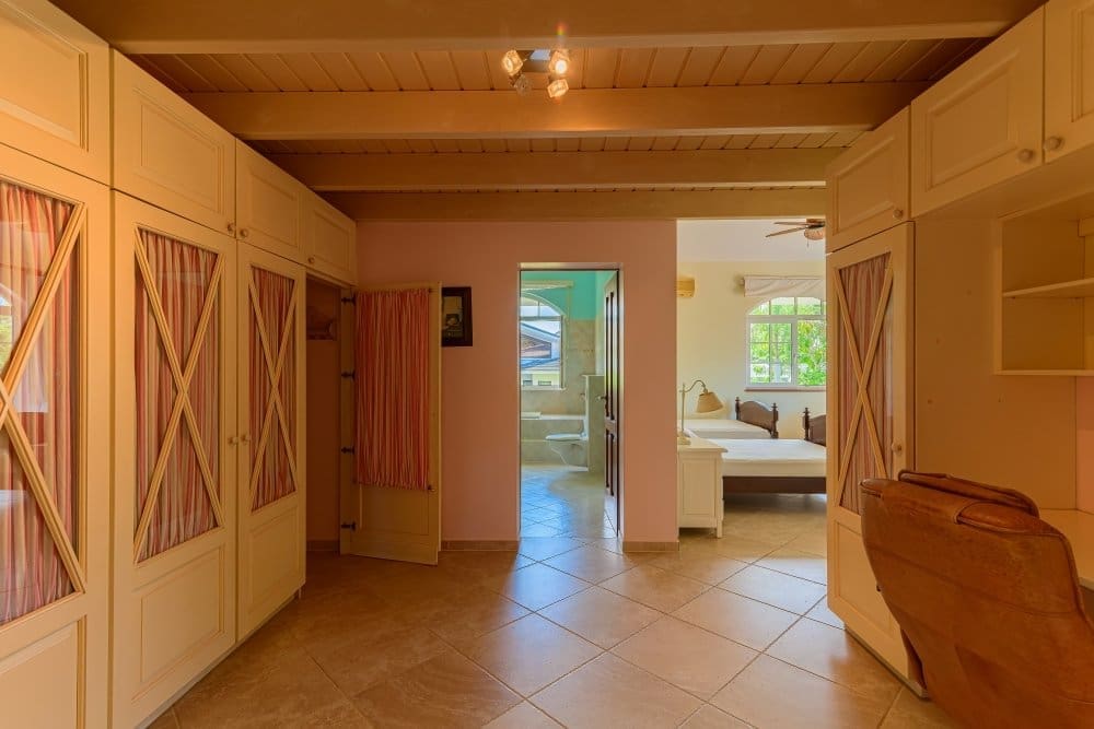 buyDRproperty Spacious master bedroom with walk-in closet, ensuite bathroom, and king-size bed. Sosua Real Estate