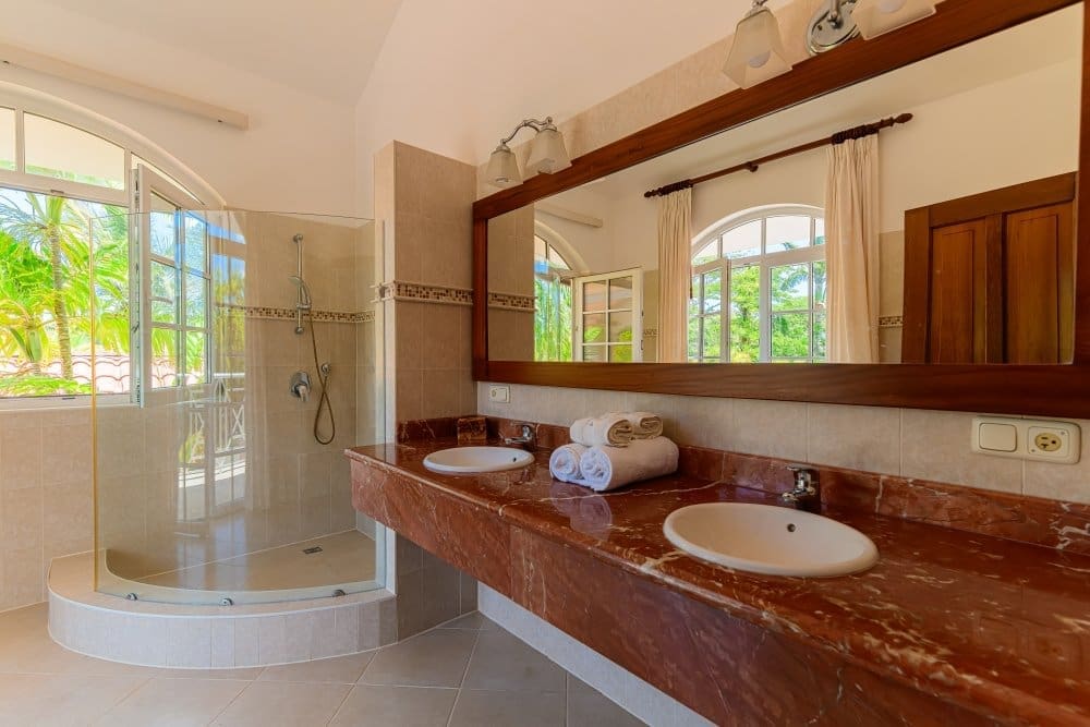 buyDRproperty Luxurious master bathroom with double vanity, marble countertop, and walk-in shower. Sosua Real Estate