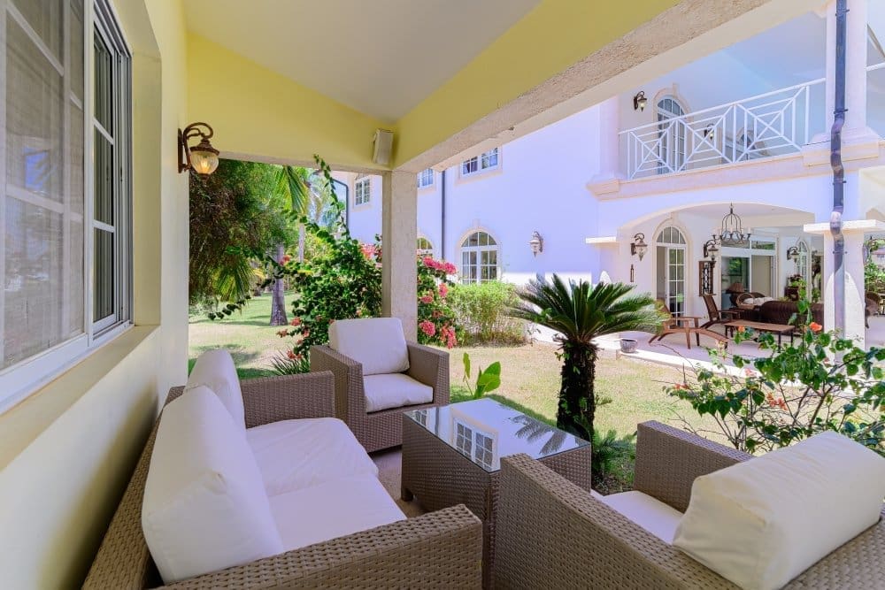 buyDRproperty Outdoor patio furniture on a covered porch with a tropical garden view Sosua Real Estate