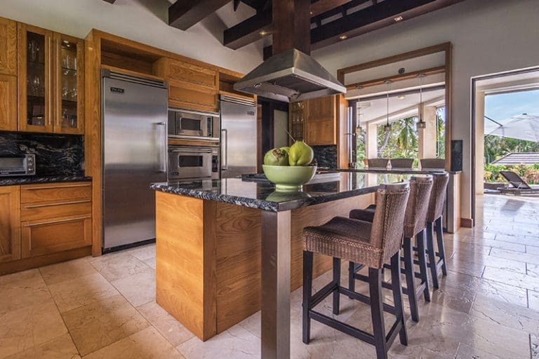 buyDRproperty Modern kitchen with island, stainless steel appliances, and bar stools. Sosua Real Estate