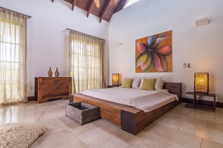 buyDRproperty Spacious master bedroom with a king-size bed, wooden furniture, and large windows. Sosua Real Estate