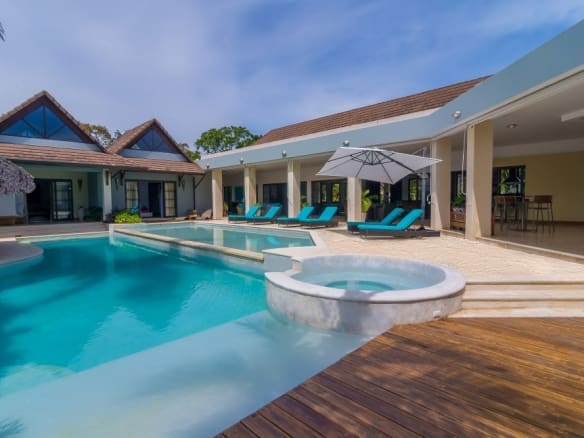 buyDRproperty Luxury villa with pool, hot tub, and lounge chairs in a tropical setting. Sosua Real Estate