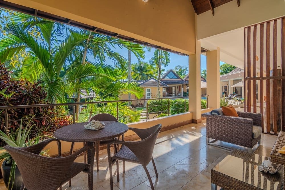 buyDRproperty Tropical patio with wicker furniture and lush palm trees Sosua Real Estate