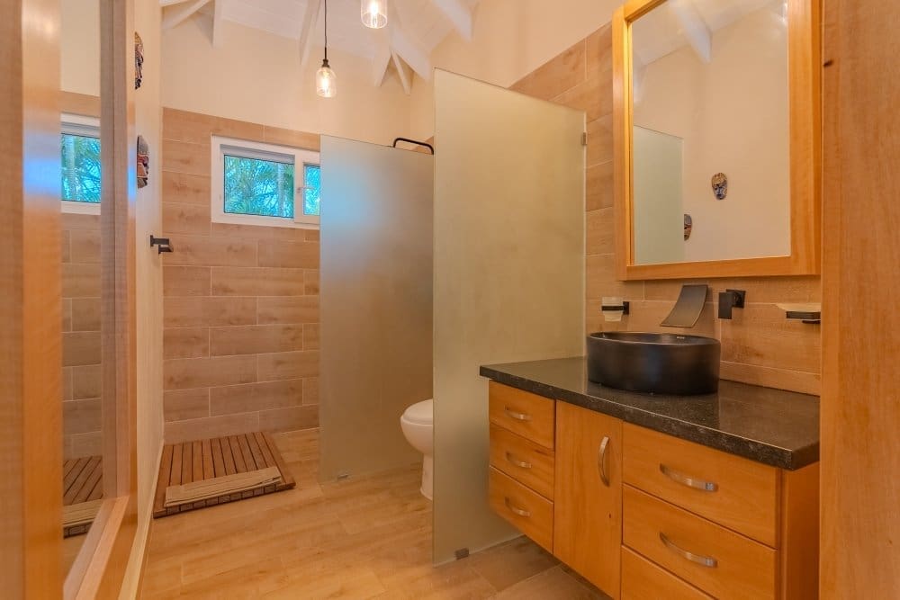 buyDRproperty Modern bathroom with wood accents, walk-in shower, and vessel sink Sosua Real Estate