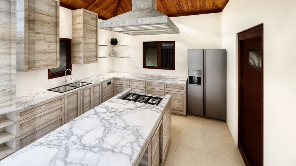 buyDRproperty Luxurious modern kitchen with marble island, stainless steel appliances, and wood ceiling. Sosua Real Estate