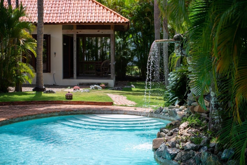 buyDRproperty Tropical villa with pool and waterfall, lush green palm trees Sosua Real Estate