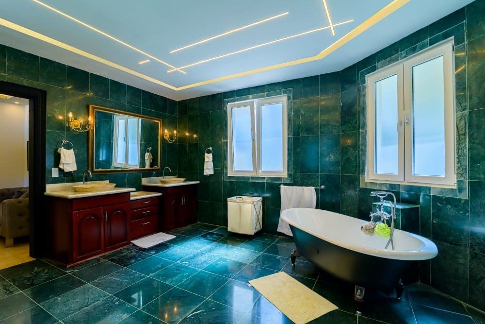buyDRproperty Luxurious green marble bathroom with a freestanding tub and double vanity. Sosua Real Estate