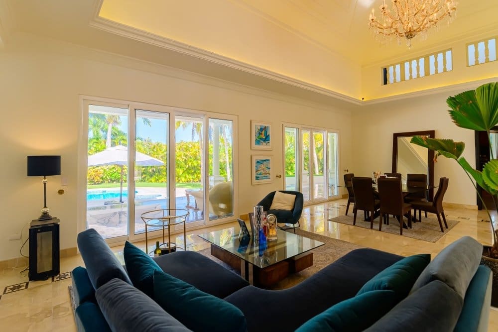 buyDRproperty Luxury living room with pool view, modern furniture, and dining area Sosua Real Estate