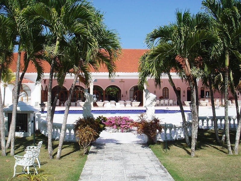 buyDRproperty Pink Mediterranean villa with palm trees and swimming pool Sosua Real Estate