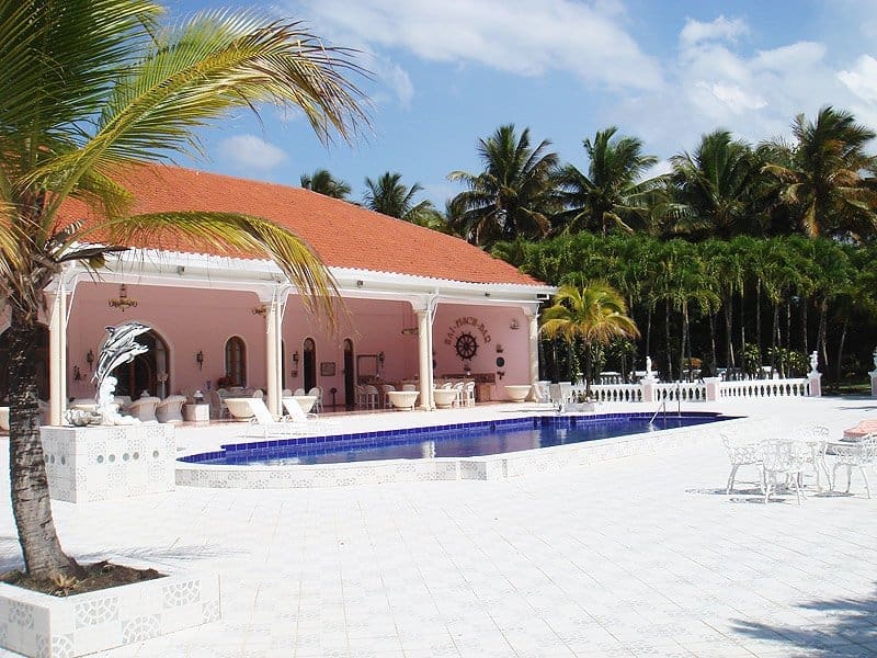 buyDRproperty Pink villa with pool and palm trees, tropical resort setting Sosua Real Estate